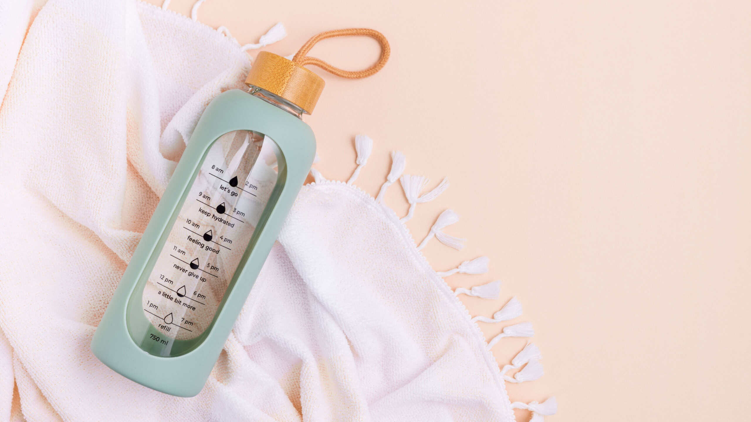 Water bottle and towel on a light background.