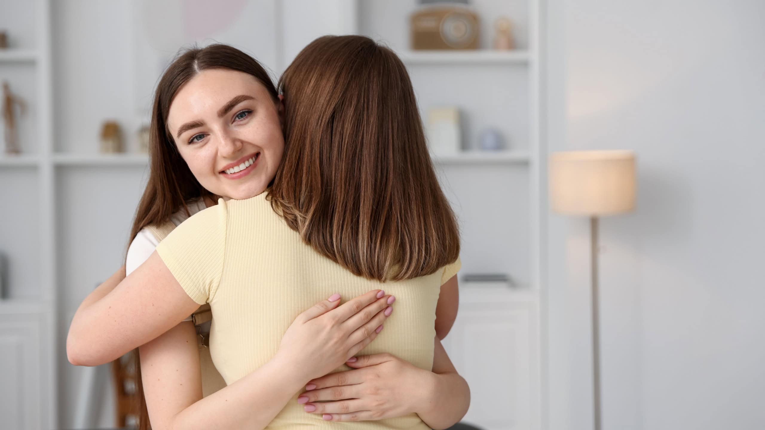 Happy friends hugging after apology at home. Space for text