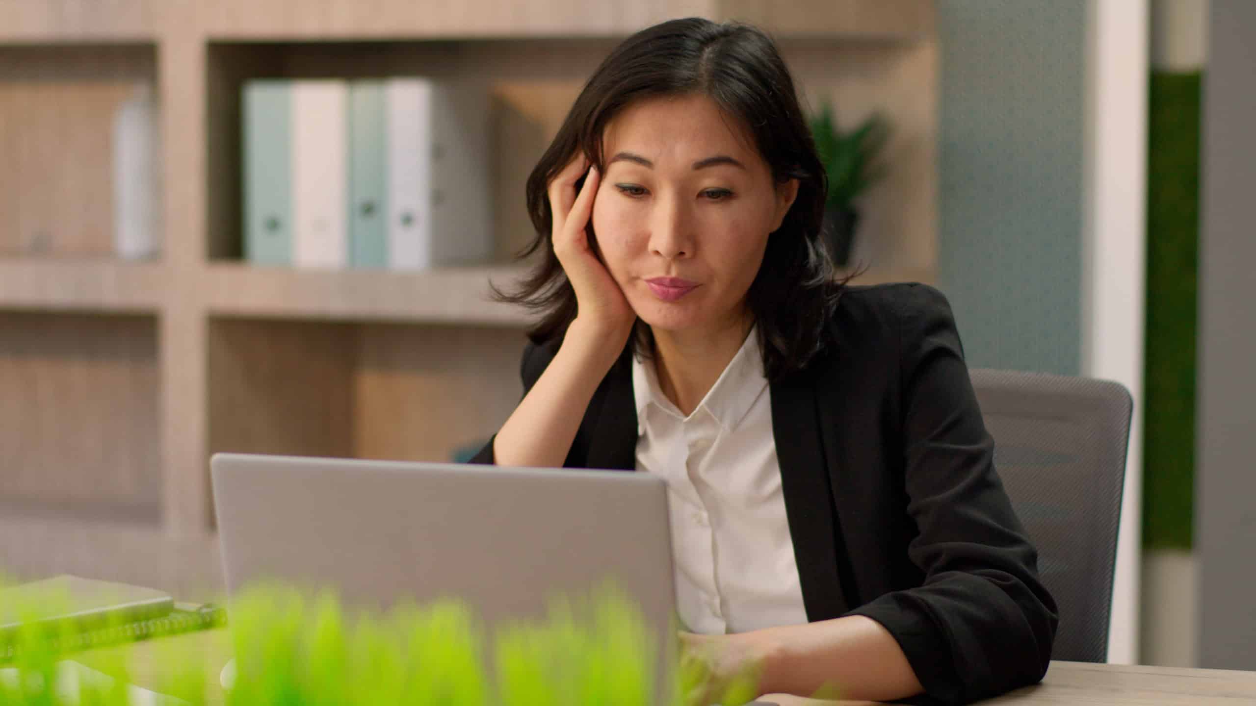 Asian adult businesswoman girl Chinese Korean business woman female employer manager boring online work typing laptop tired exhausted bored Japanese lady think sad apathy fatigue overwork at office