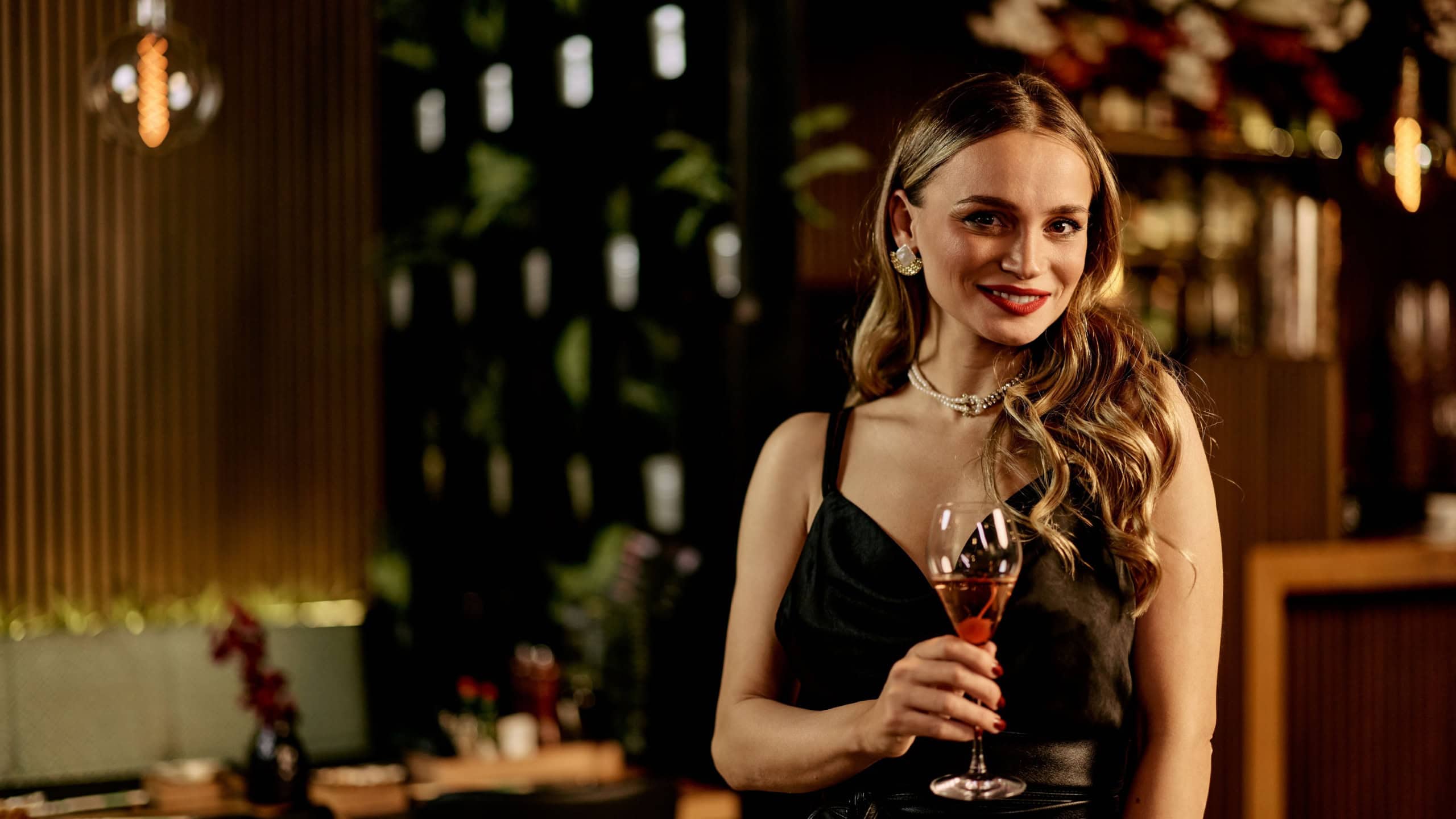 A stylish lady enjoying a drink in a high-end restaurant setting