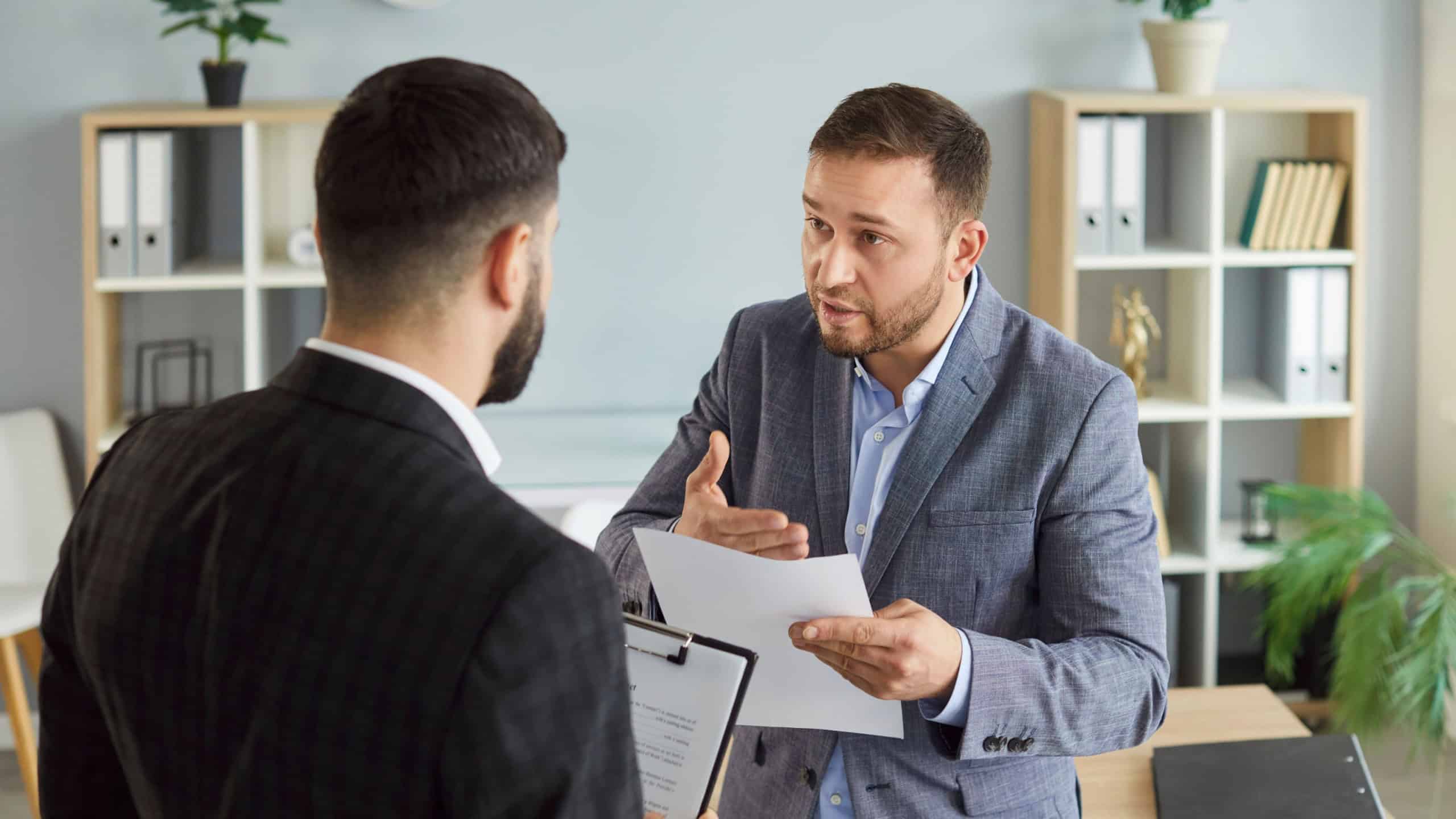 Dissatisfied business people colleagues disputing having disagreement at workplace. Displeased coworkers arguing having conflict standing in office discussing contract. Business conflict concept.
