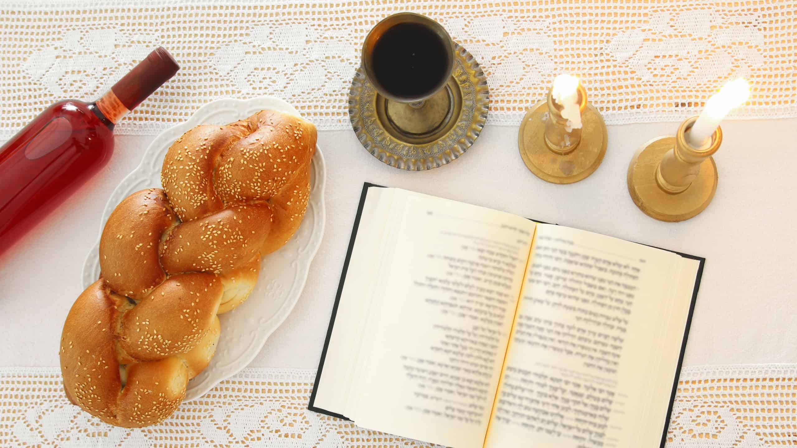 shabbat image. challah bread, shabbat wine and candles on the table. Top view