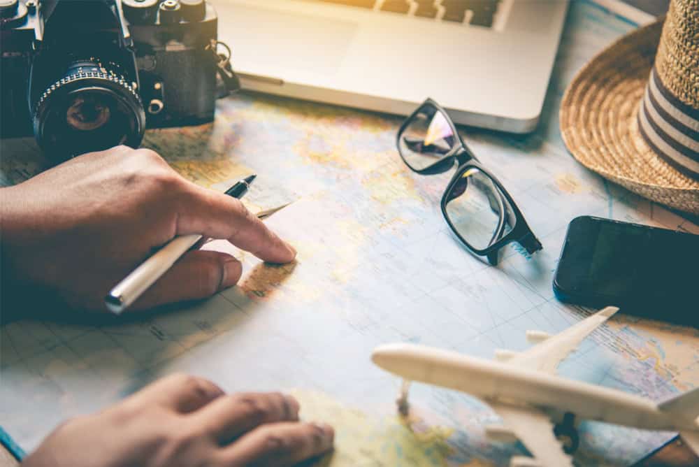 Travelers are planning a trip by searching the route on the map and searching for information on the internet